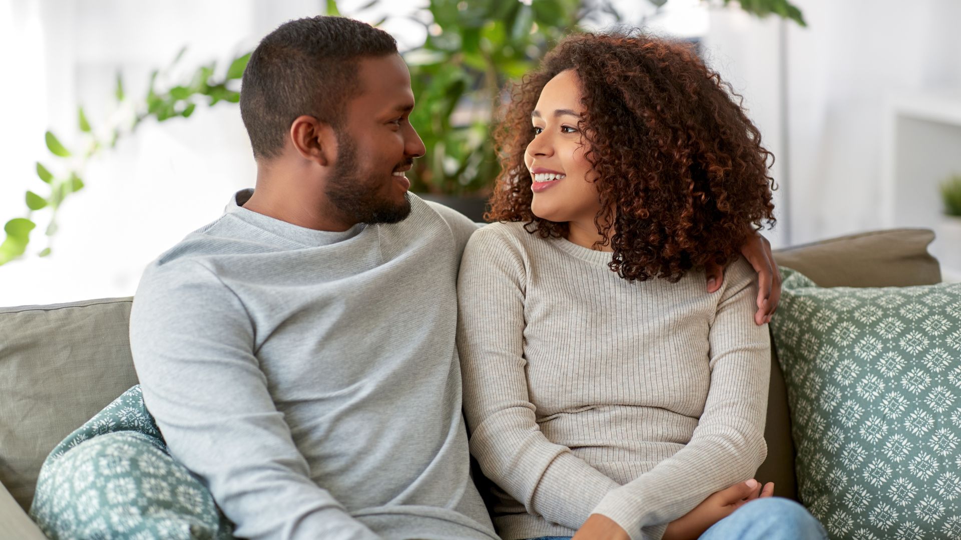 Young Couple Talking on Sofa at Home